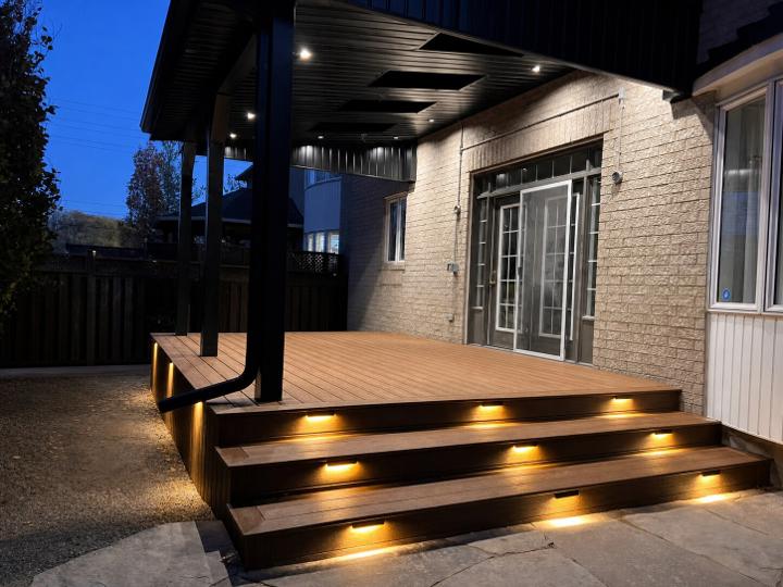 Covered composite deck with steps and built-in lighting at dusk