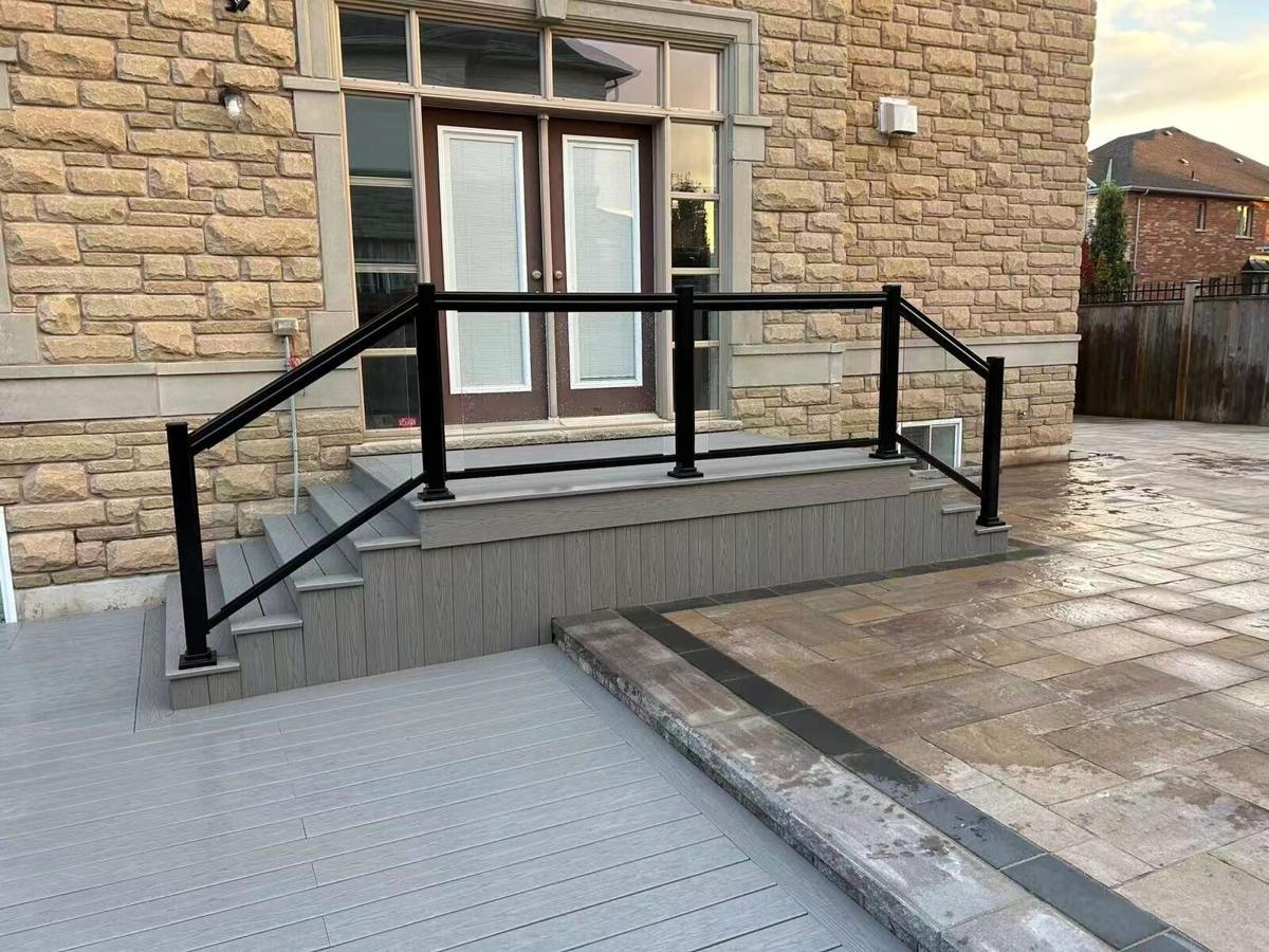 Grey composite entrance landing and steps with a black railing