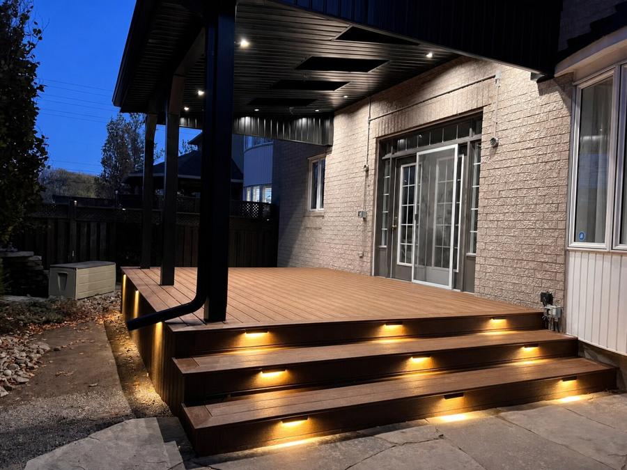 Covered composite deck at dusk with steps and built-in lighting