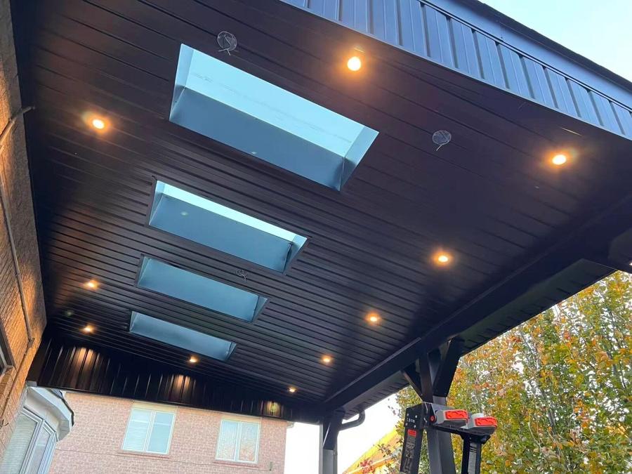 Dark covered porch roof with skylights and recessed lights viewed from below