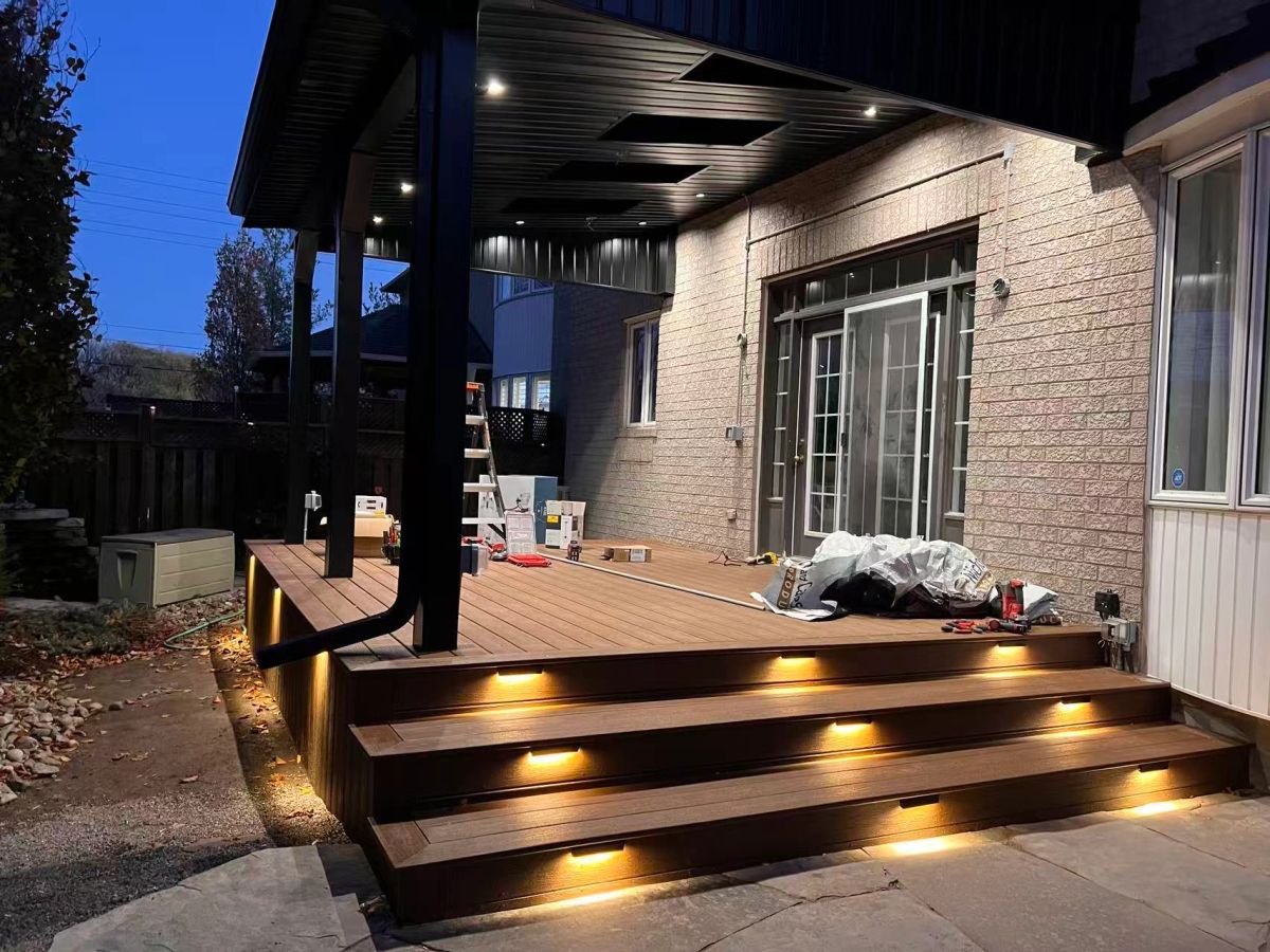 Composite deck and patio lit at dusk